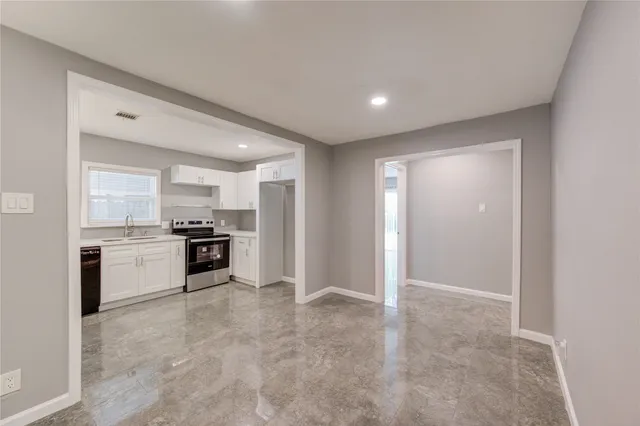 a large white kitchen with a stove a sink and a refrigerator