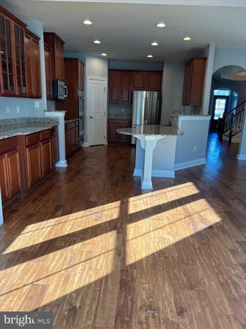 a kitchen with stainless steel appliances granite countertop wooden cabinets a oven a stove and a sink with granite countertops