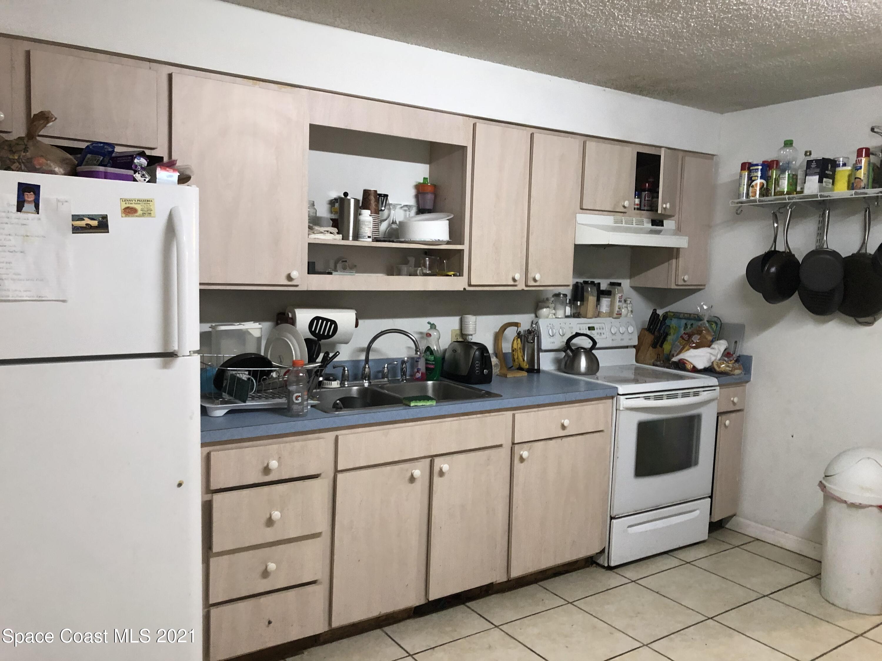 435 Count Street Melbourne, FL 32901 - Photo 2 of 7 a kitchen with white cabinets and white appliances