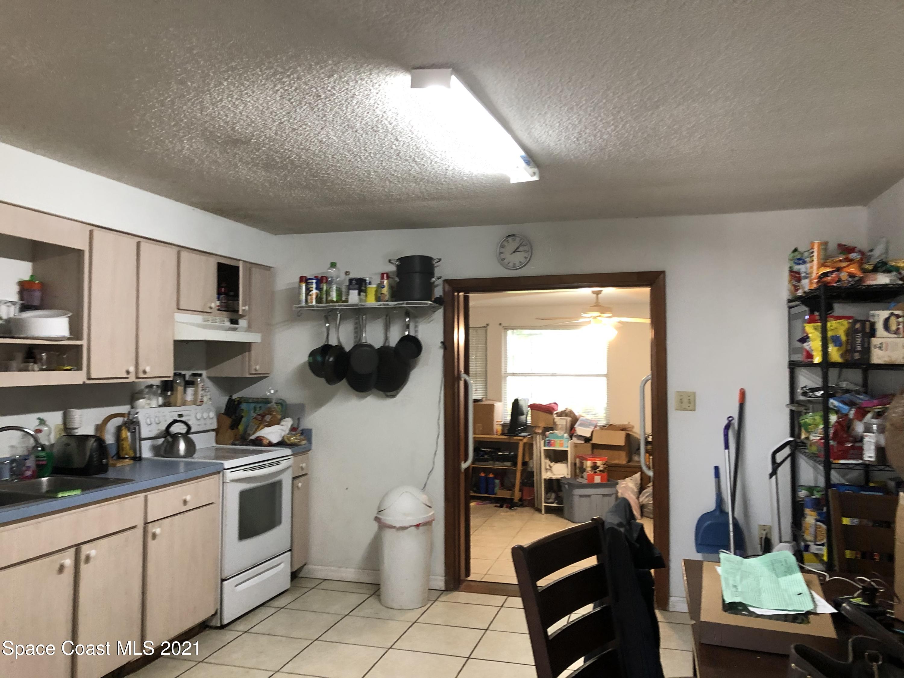 435 Count Street Melbourne, FL 32901 - Photo 6 of 7 a kitchen with stainless steel appliances kitchen island granite countertop a refrigerator and a sink