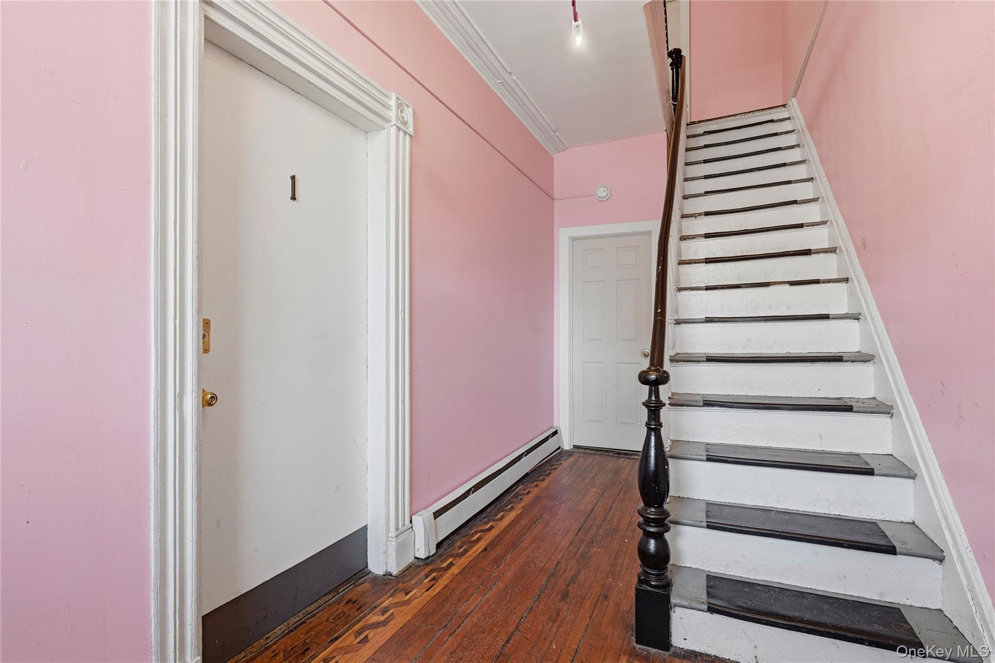 203 Grand Street, Unit 1 Newburgh, NY 12550 - Photo 9 of 10 Stairs featuring a baseboard radiator and wood-type flooring