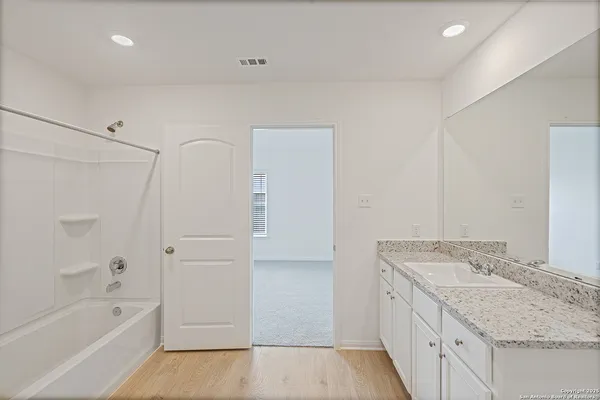a bathroom with a granite countertop sink a toilet and bathtub