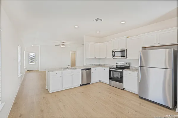 a kitchen with a refrigerator a stove top oven a sink and dishwasher