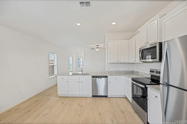 a kitchen with granite countertop a sink stove and refrigerator