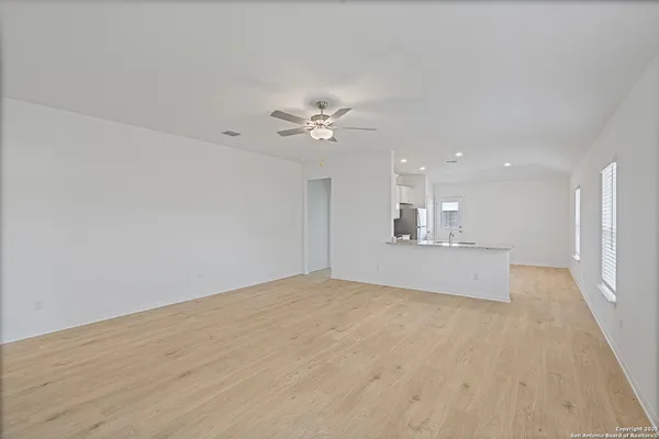 a view of an empty room with a kitchen