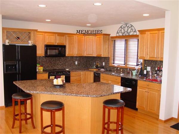 81 Edgewater Road Mashpee, MA 02649 - Photo 5 of 13 a kitchen with stainless steel appliances granite countertop a stove a refrigerator a sink a dining table and chairs