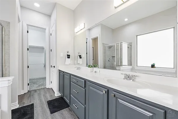 a spacious bathroom with a double vanity sink a mirror and a shower