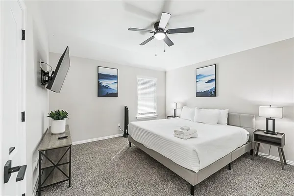 a bedroom with a bed a couch and a flat screen tv