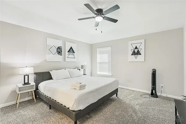 a bedroom with a bed chandelier and a window