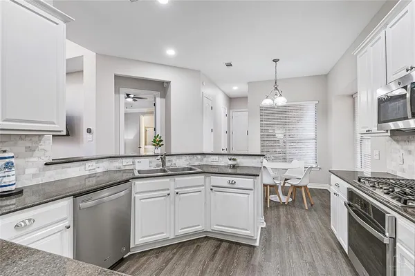 a kitchen with white cabinets and appliances