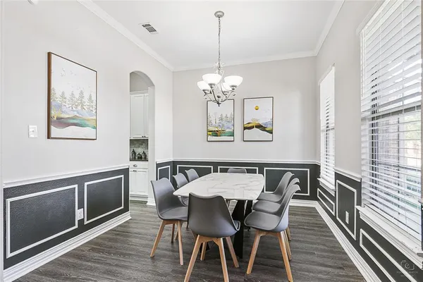 a view of a dining room with furniture a chandelier and wooden floor