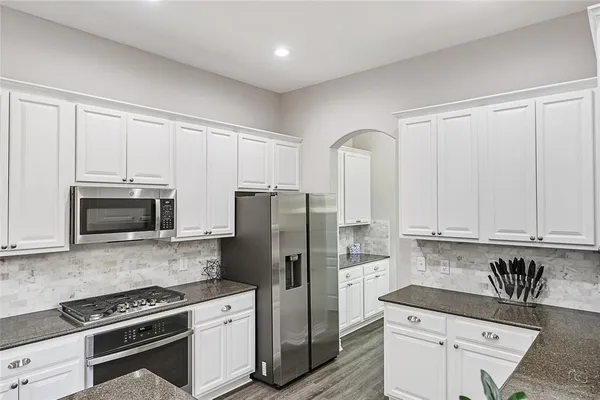 a kitchen with stainless steel appliances granite countertop a refrigerator sink and stove