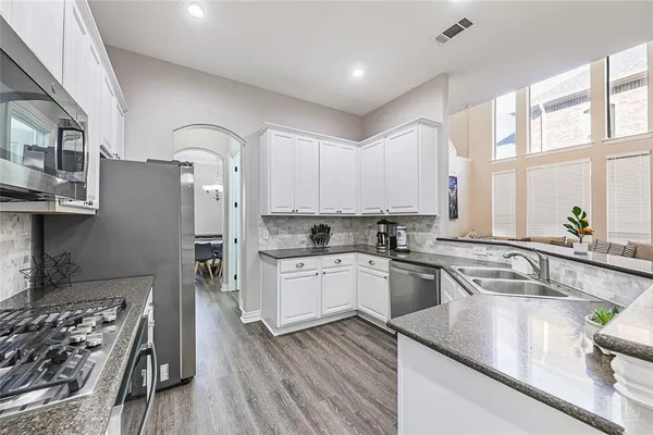 a kitchen with stainless steel appliances granite countertop a sink stove and refrigerator