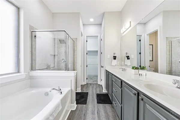 a spacious bathroom with a tub sink shower and mirror