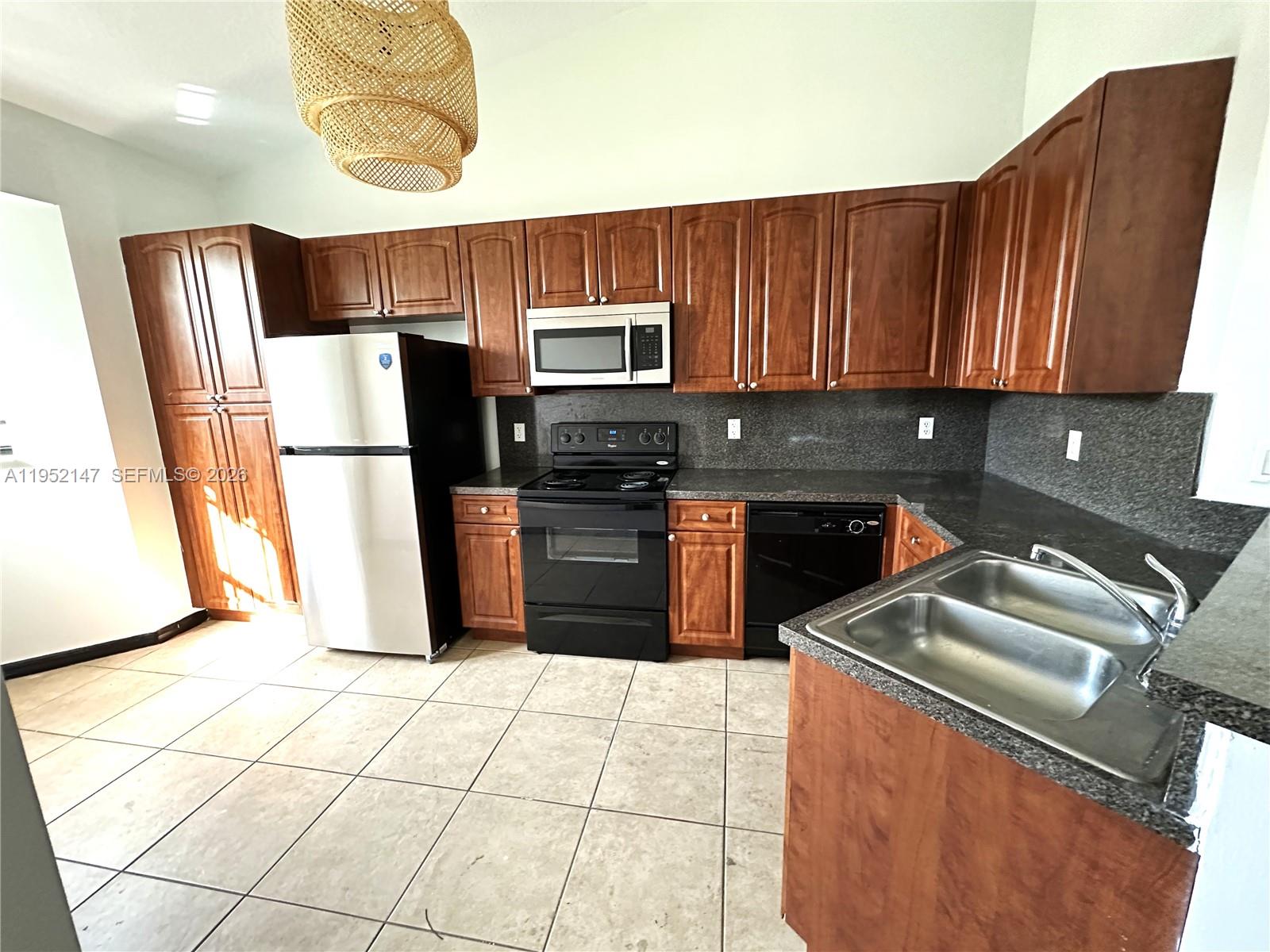 3550 Northeast 5th Street, Unit 202 Homestead, FL 33033 - Photo 12 of 23 a kitchen with stainless steel appliances a refrigerator sink and cabinets