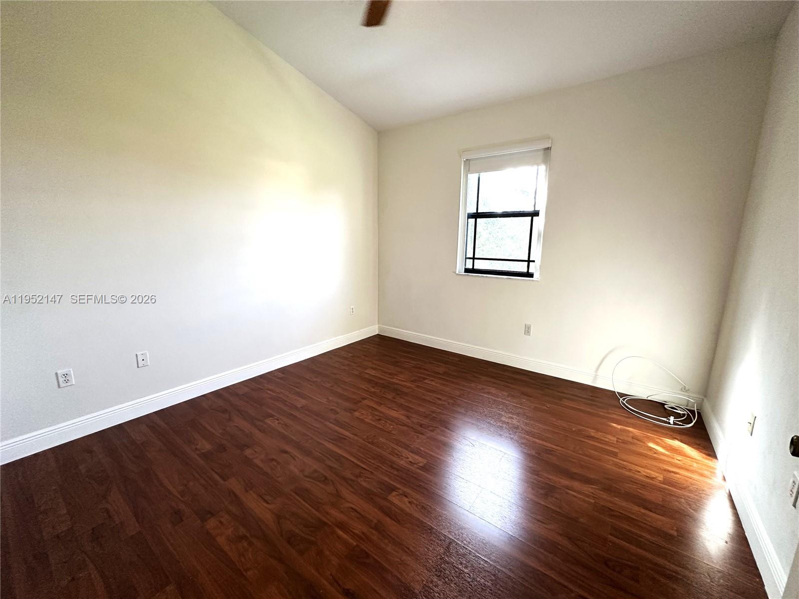 3550 Northeast 5th Street, Unit 202 Homestead, FL 33033 - Photo 15 of 23 an empty room with wooden floor and windows