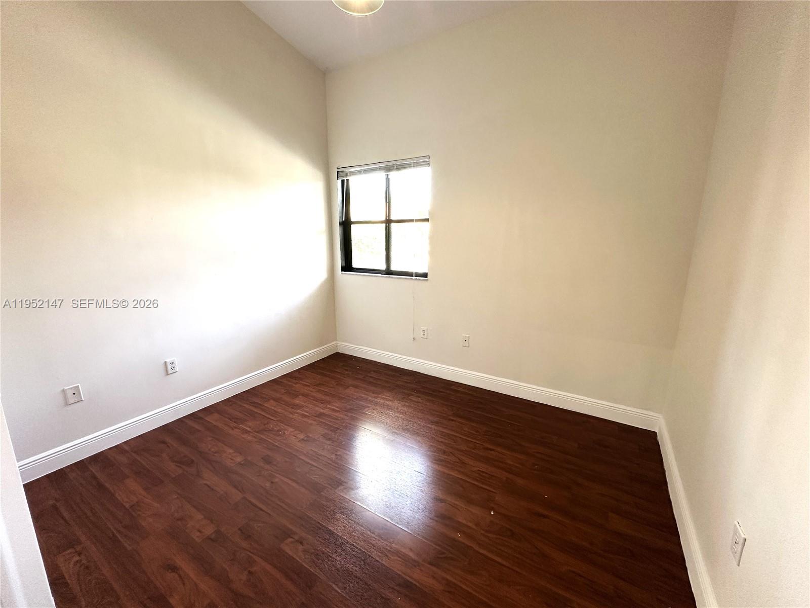 3550 Northeast 5th Street, Unit 202 Homestead, FL 33033 - Photo 20 of 23 an empty room with wooden floor and windows