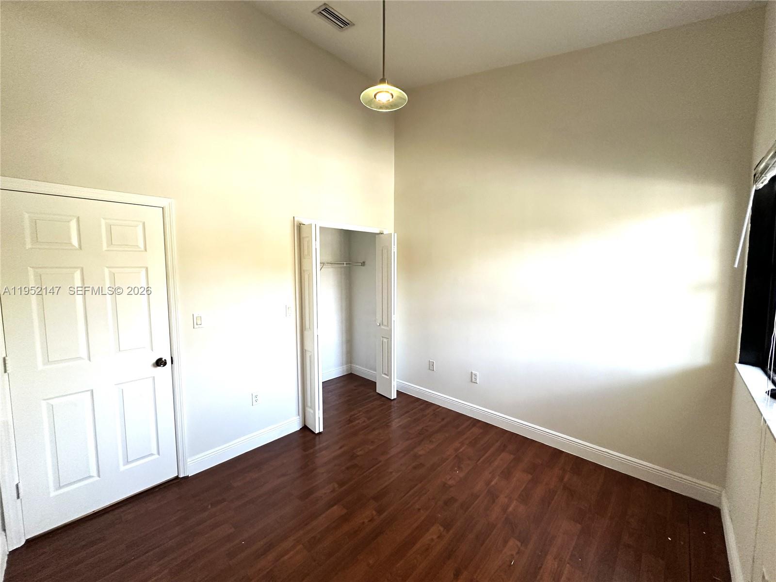 3550 Northeast 5th Street, Unit 202 Homestead, FL 33033 - Photo 21 of 23 an empty room with wooden floor and windows