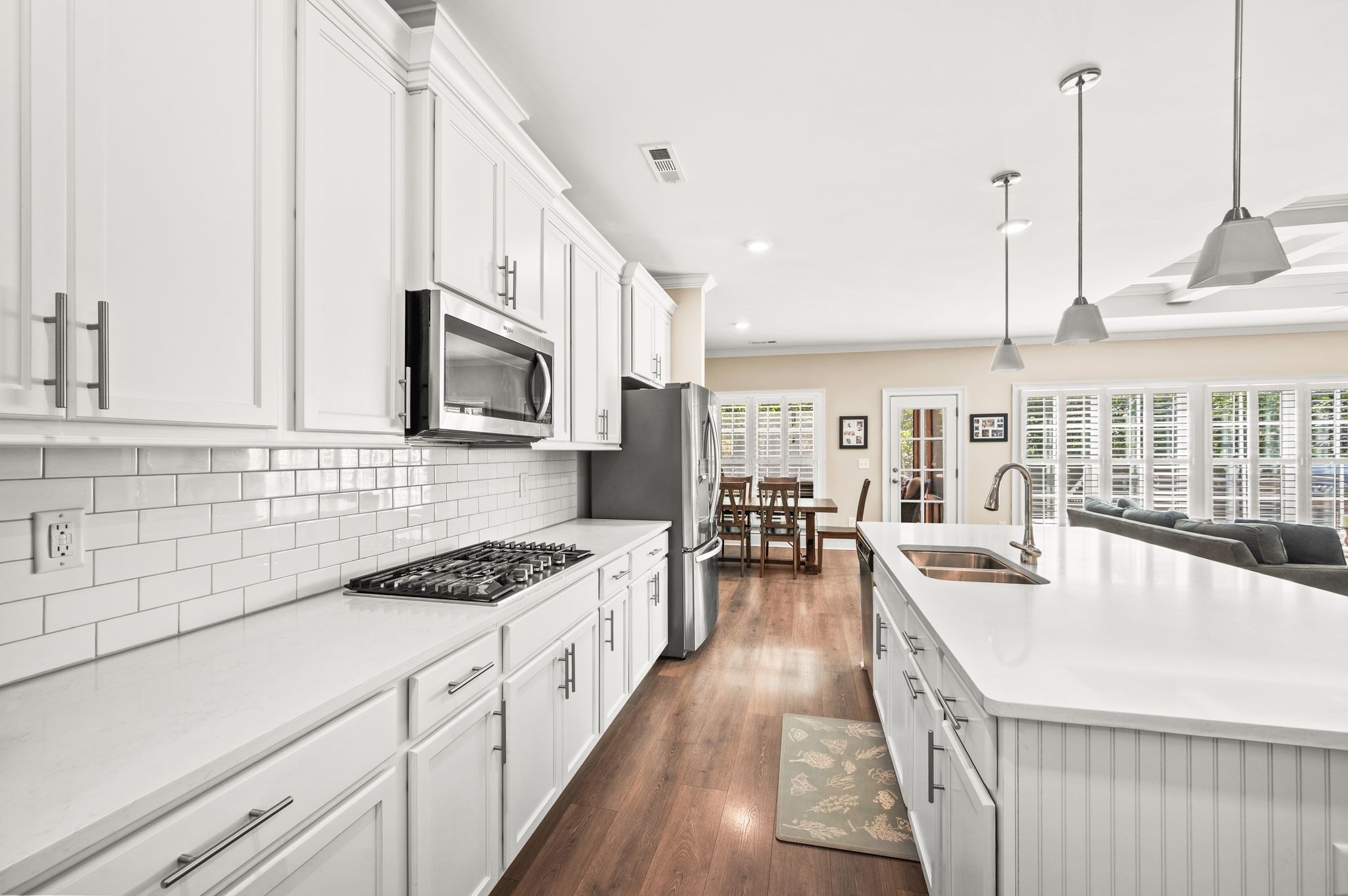 7345 Taylor Road Fairview, TN 37062 - Photo 18 of 65 a kitchen with stainless steel appliances a stove a sink a oven a dining table with white cabinets and wooden floor