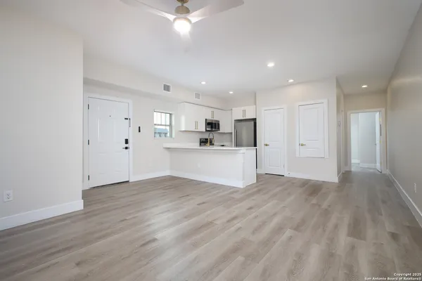 a view of a kitchen with a sink and dishwasher a refrigerator with wooden floor