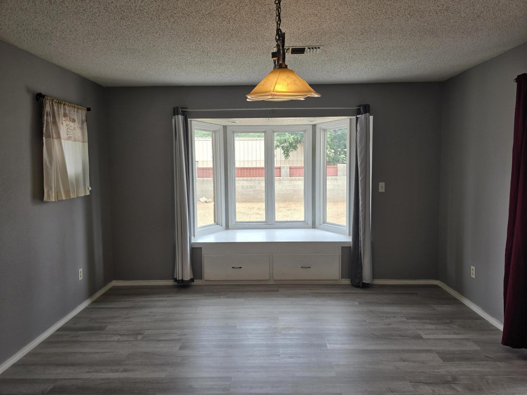 506 North 19th Street Lamesa, TX 79331 - Photo 11 of 29 an empty room with wooden floor and windows