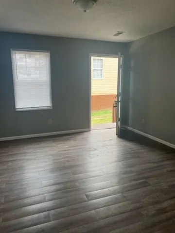 an empty room with wooden floor and a window