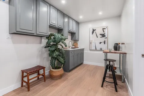 a kitchen with stainless steel appliances kitchen island granite countertop a table chairs in it and wooden floors