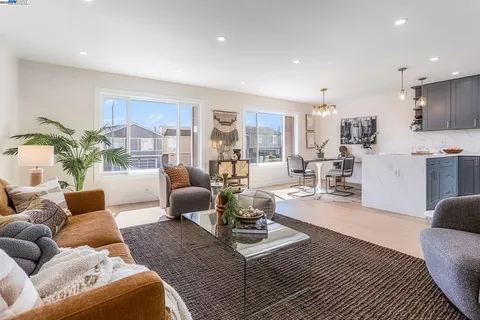 a living room with furniture and a view of kitchen