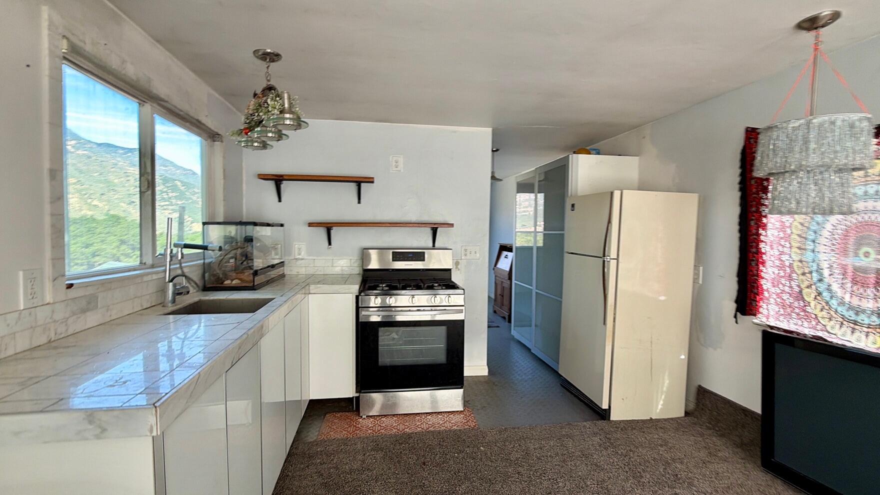 3750 Paradise Road, Unit 97 Santa Barbara, CA 93105 - Photo 2 of 17 a kitchen with a refrigerator a stove cabinets and a window