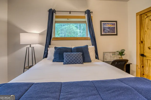 a view of house with a big yard and large trees