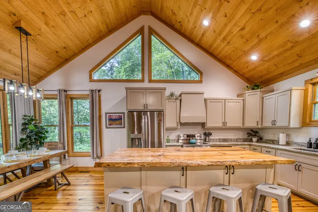 a living room with furniture a large window and wooden floors