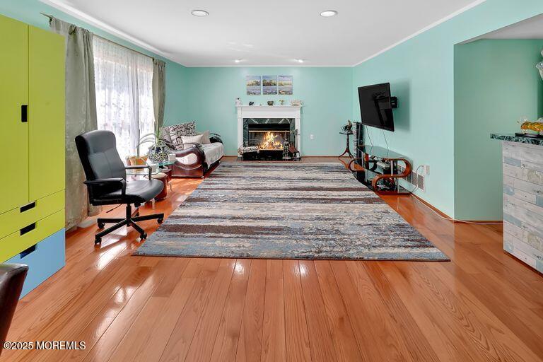 389 Aldrich Road Howell, NJ 07731 - Photo 17 of 55 a living room with furniture a fireplace and a flat screen tv