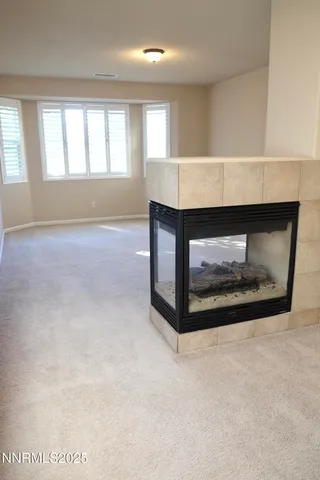 an empty room with windows and fireplace