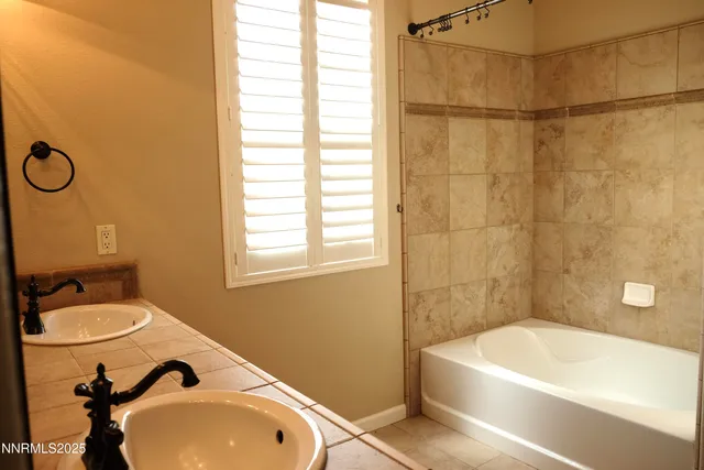 a bathroom with a tub a sink and a mirror