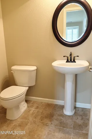 a bathroom with a toilet a sink and a mirror