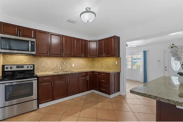 a kitchen with granite countertop a stove microwave and cabinets