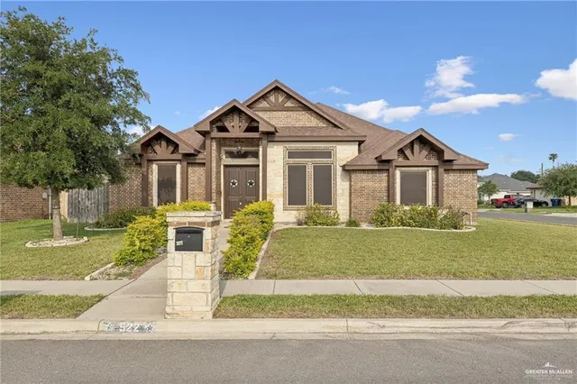 a front view of a house with a garden and yard