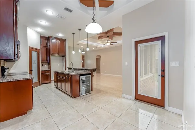 a view of a kitchen with granite countertop a refrigerator and a sink