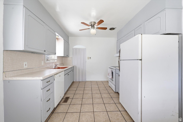 676 South 500 West Provo, UT 84601 - Photo 8 of 29 Kitchen with white appliances, light countertops, ceiling fan, light tile patterned flooring, and white cabinets