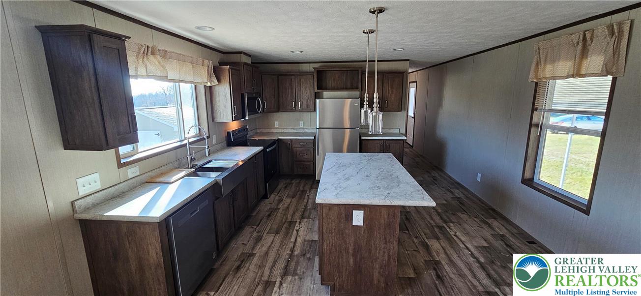 2501 Fox Road Bath, PA 18014 - Photo 4 of 11 a kitchen with stainless steel appliances granite countertop a refrigerator a sink dishwasher a stove and white countertops with wooden floor