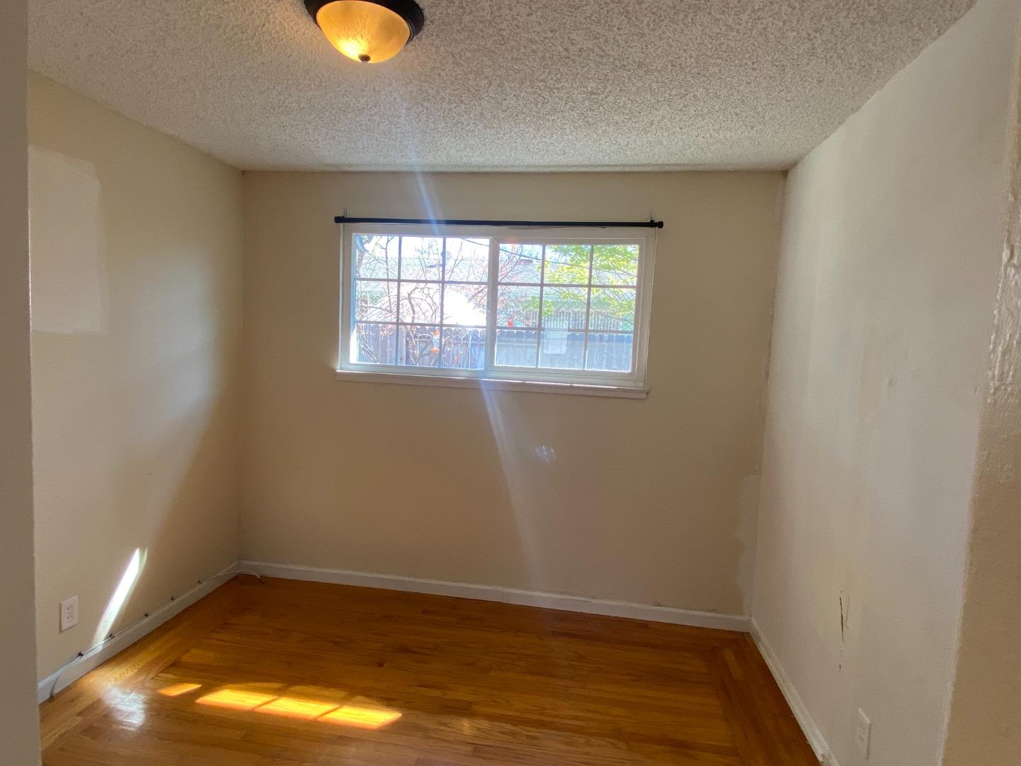 1312 Carleton Drive Concord, CA 94518 - Photo 12 of 16 an empty room with wooden floor and windows