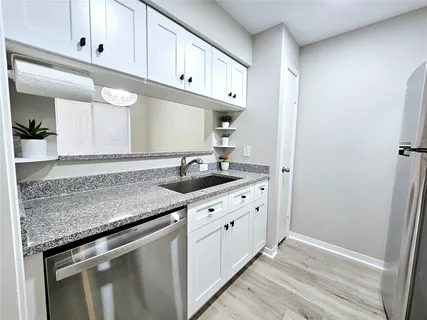 a kitchen with granite countertop a sink and cabinets