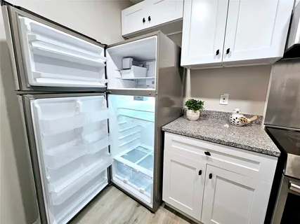 a kitchen with granite countertop a refrigerator and a sink