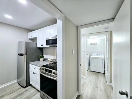 a kitchen with white cabinets and stainless steel appliances