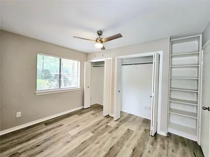 a view of a bedroom with a ceiling fan and a window