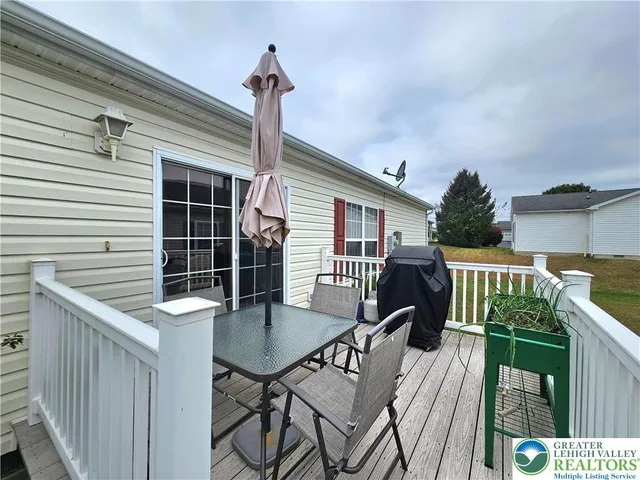 a roof deck with table and chairs and wooden floor