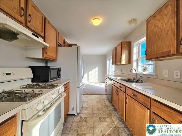a large kitchen with stainless steel appliances granite countertop a stove and a sink