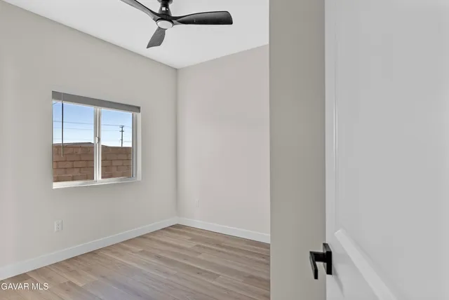 an empty room with wooden floor and mirror