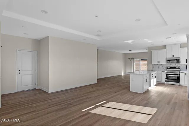 a kitchen with granite countertop a refrigerator and a stove top oven