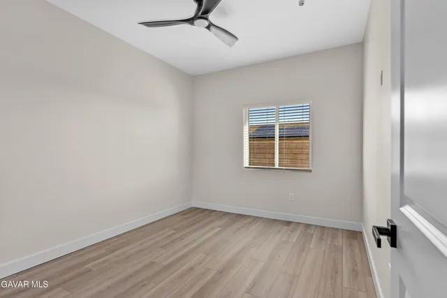 a view of a kitchen from the hallway with wooden floor